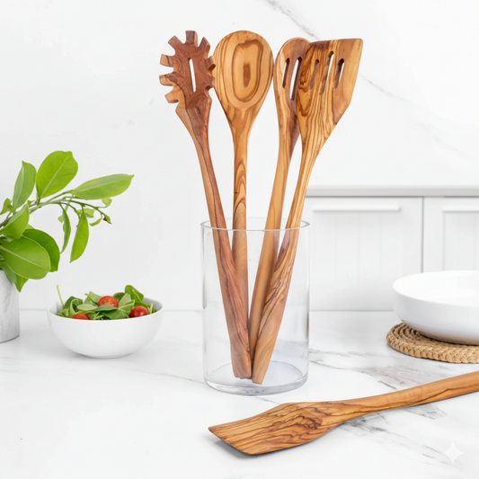 Set of wooden kitchen utensils in a glass container on a kitchen counter.
