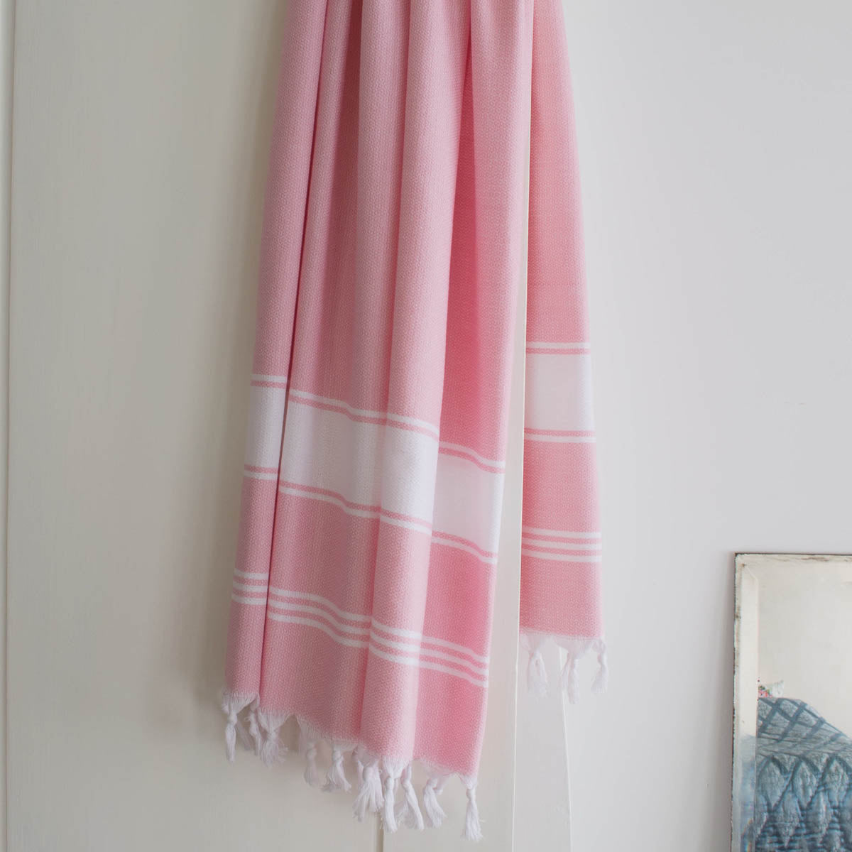 pink fouta towel drapped on a door. Lightweight, quick-dry, 100% cotton towel,beach towel, hammam & spa towel