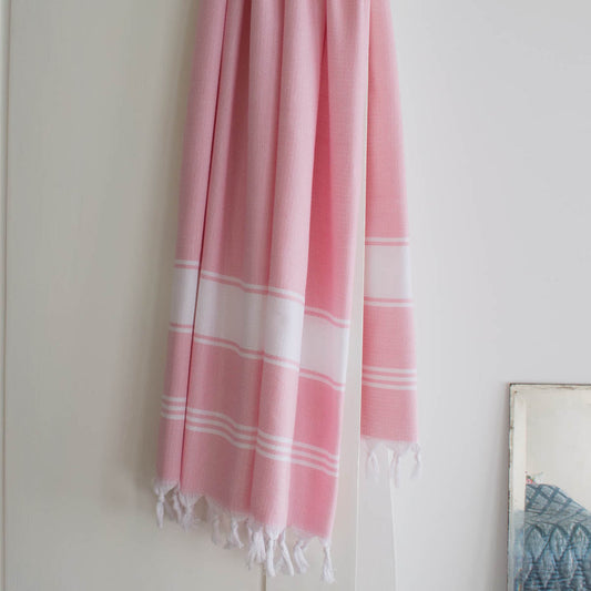 pink fouta towel drapped on a door. Lightweight, quick-dry, 100% cotton towel,beach towel, hammam & spa towel