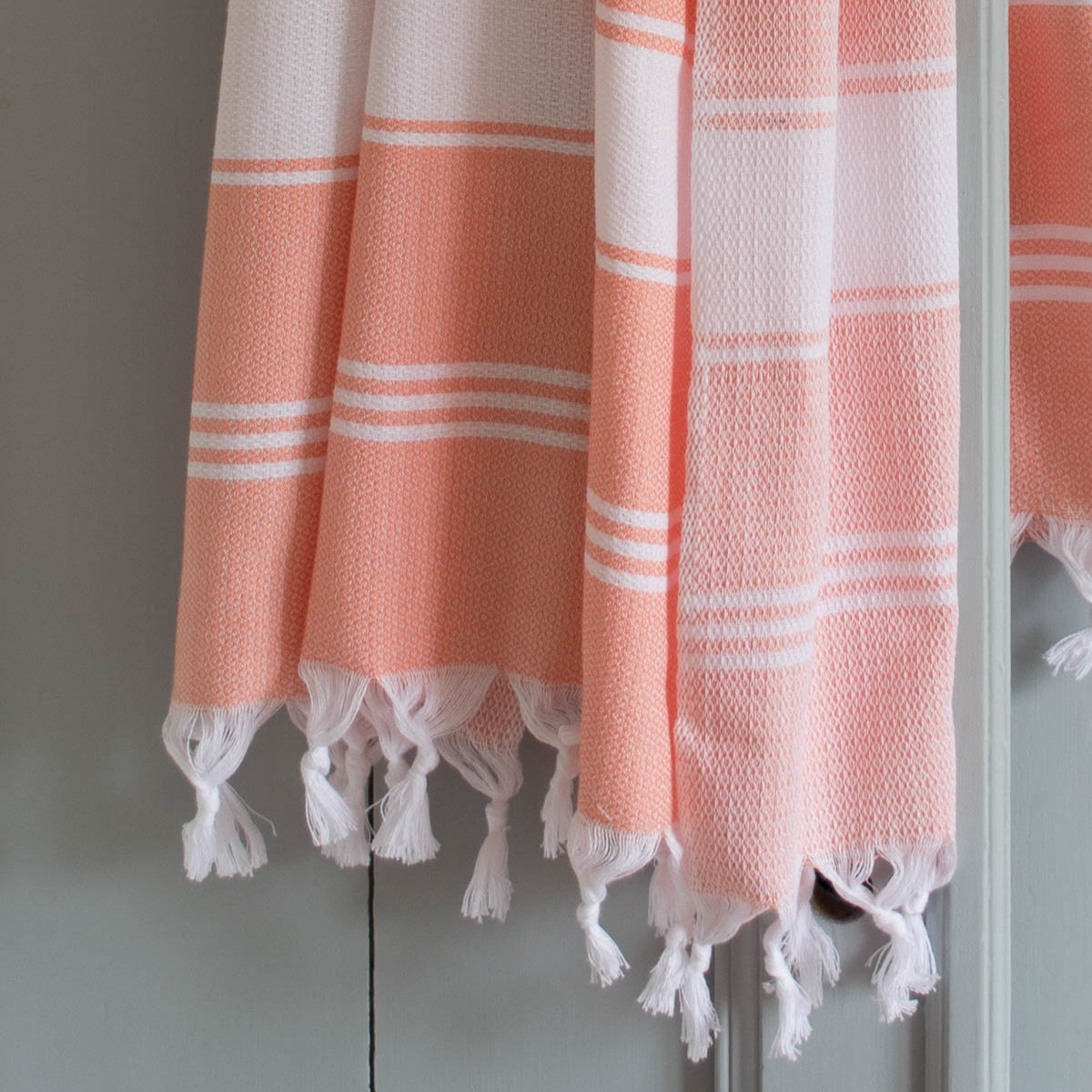 orange fouta towel on a a door, bathroom towel, hammam towel, beach towell, spa towel, cotton towel, quick-dry towel, lightwheight towel, turkish towel