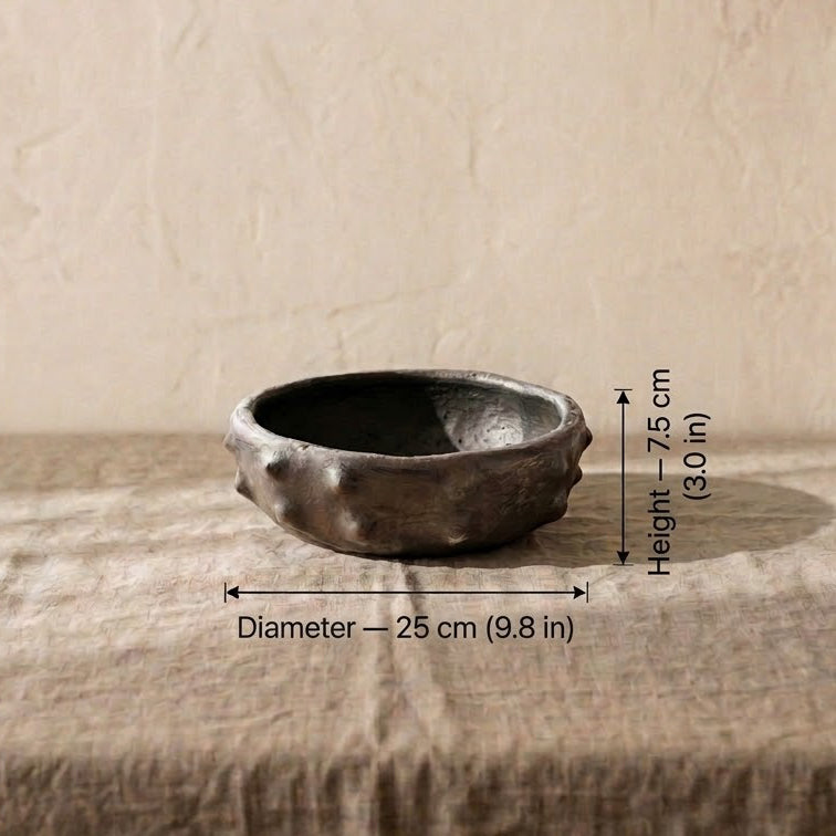 A rustic sejnane pottery ceramic bowl with rough, textured sides, shown on a fabric-covered surface.