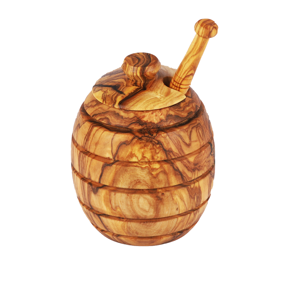 Close-up of the natural olive wood grain and handcrafted details of a honey jar and dipper set.