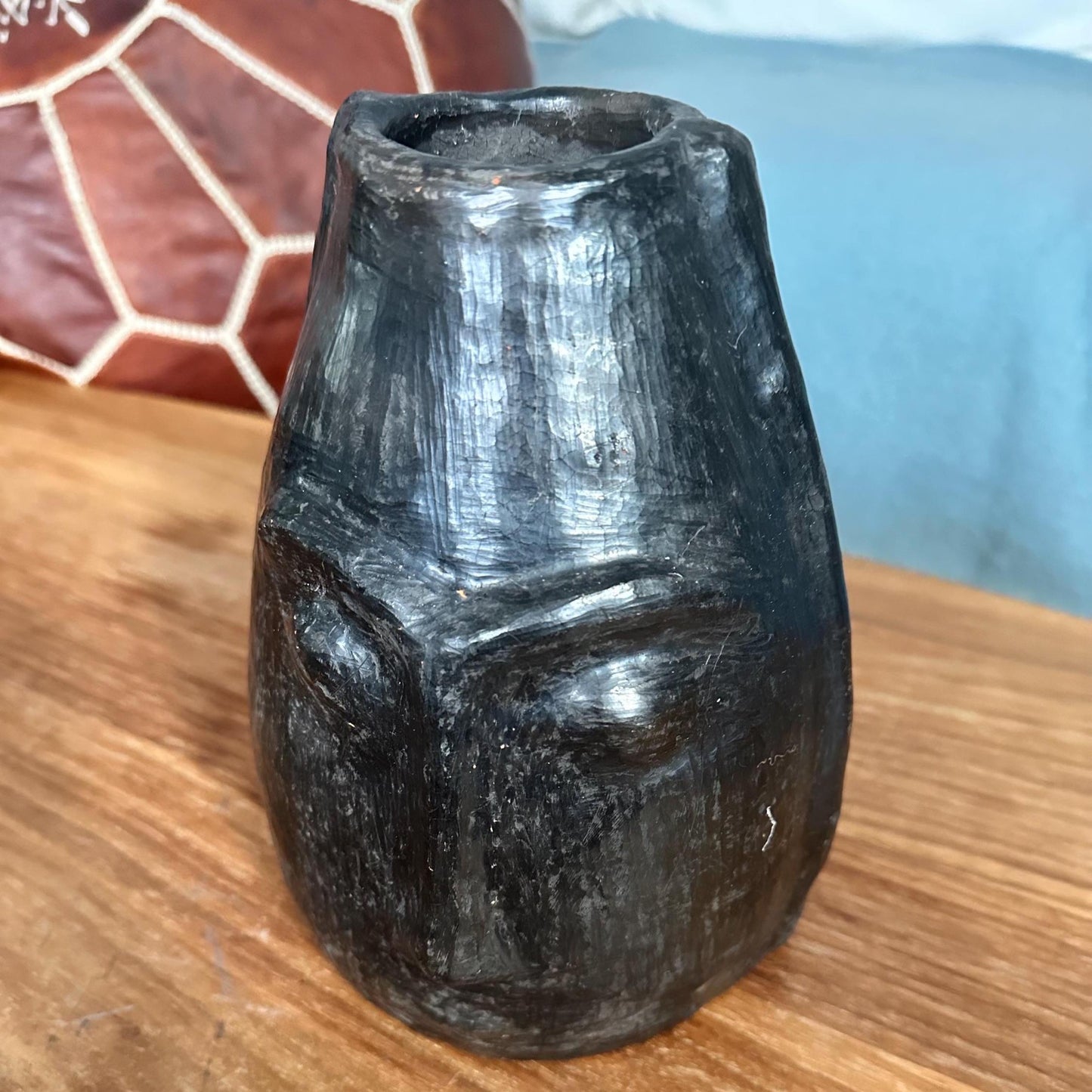 sejnane pottery vase on a wooden surface with a blurred background